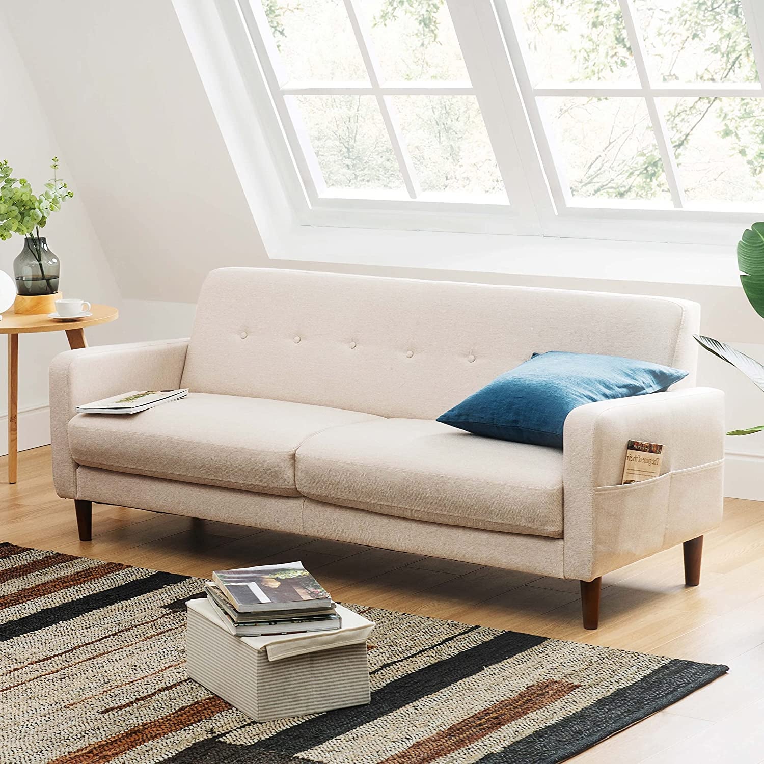 the small cream-colored sofa with armrest pockets