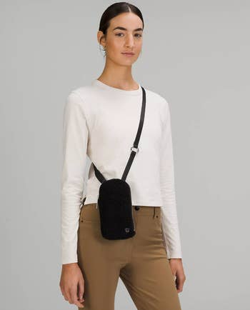 model wearing fleece crossbody bag in black