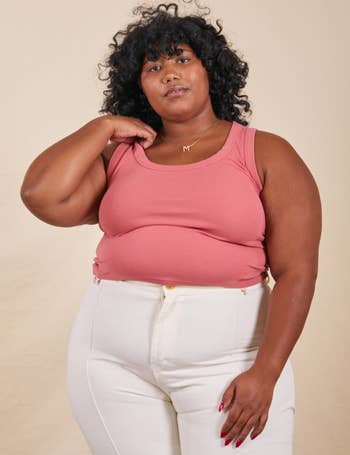 model in the pink tank top with white pants