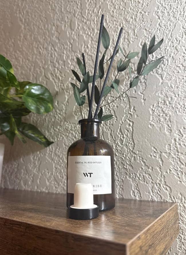 Reed diffuser with bladed  achromatic  reeds successful  a brownish  solid  vessel  labeled 