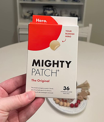 reviewer holding the white and red mighty patch box