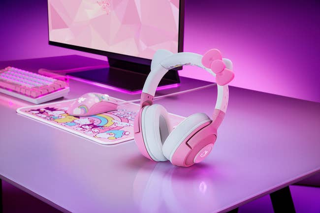 a white and pink headset with hello kitty cat ears and a pink bow