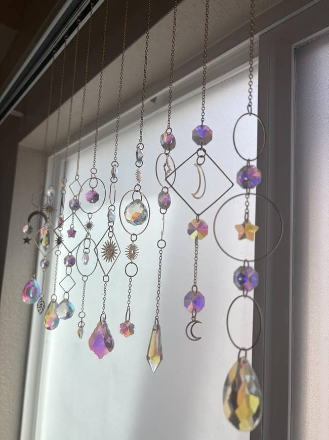 Hanging crystal and metallic  ornaments with divers  shapes seizure  airy  adjacent   a window