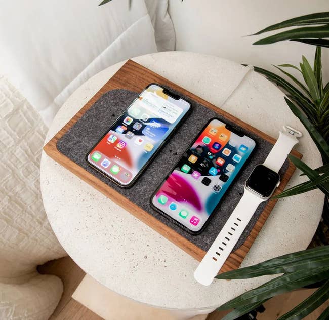 the wireless charging tray with two smart phones and watch on it