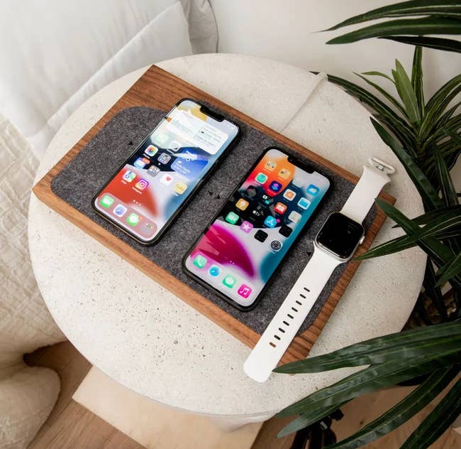 the wireless charging tray with two smart phones and watch on it