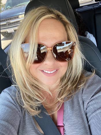a reviewer wearing the champagne crystal oversized sunglasses