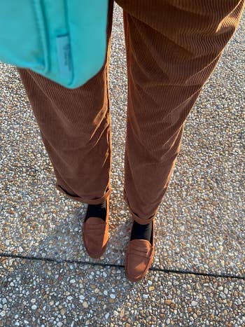 reviewer pov photo of legs, wearing brown corduroy pants and loafers
