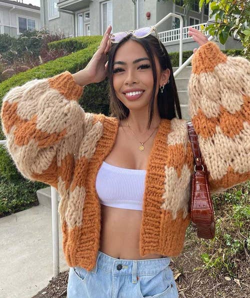 model wearing the orange and beige sweater