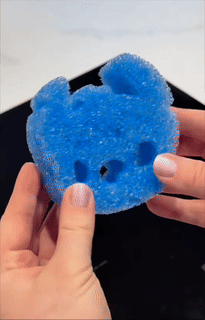 Hands clasp a bluish scrub sponge shaped similar stitch
