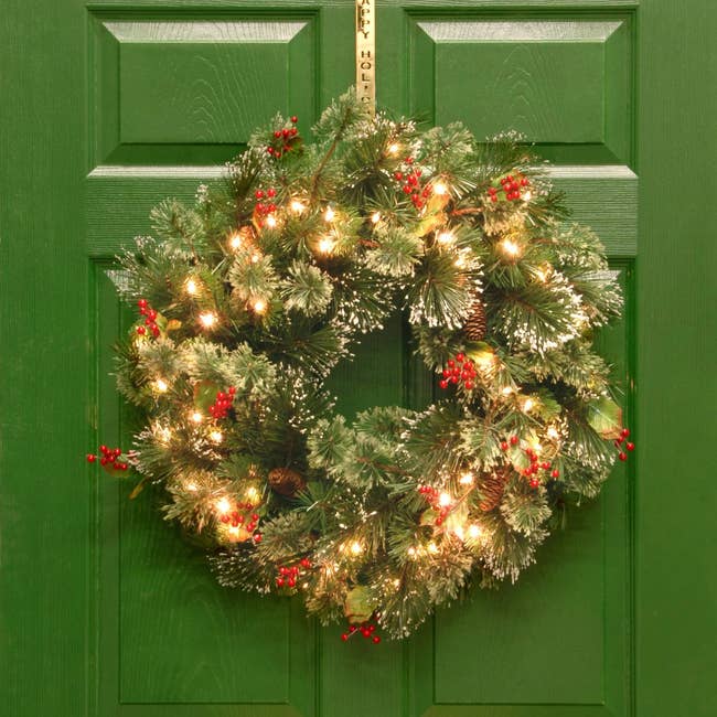 the lit wreath hung on a green door
