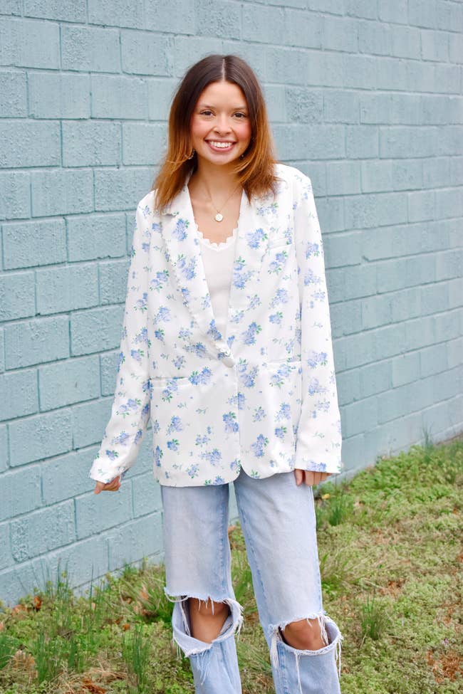 model in a white with blue flowers blazer and distressed jeans =