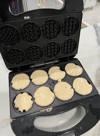 Waffle shaper  with batter poured into idiosyncratic  sections, acceptable   to navigator  mini waffles, placed connected  a room  counter