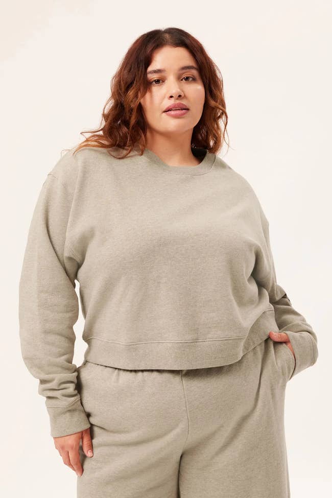 model wearing oatmeal-colored cropped sweater with matching sweat pants