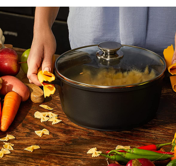 hands holding a pot full of pasta using the pasta-shaped pot holders