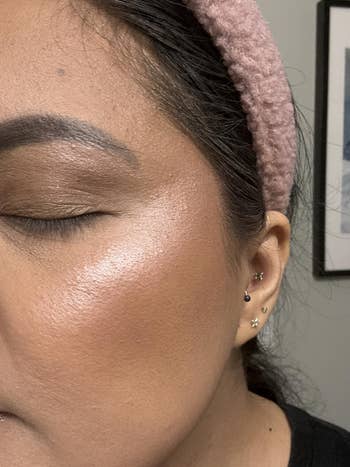 Close-up of a person's look   highlighting creaseless  tegument  and subtle makeup, featuring a textured headband and earrings successful  1  ear