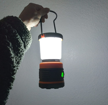 reviewer photo holding lit camping lantern