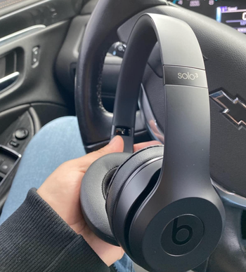 Reviewer is holding the black headphones