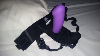 Purple dildo in black strap-on harness