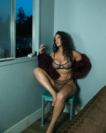 Person successful  leopard people     lingerie and furry overgarment   poses confidently indoors, sitting connected  a tiny  seat  adjacent   a window, holding a cigarette