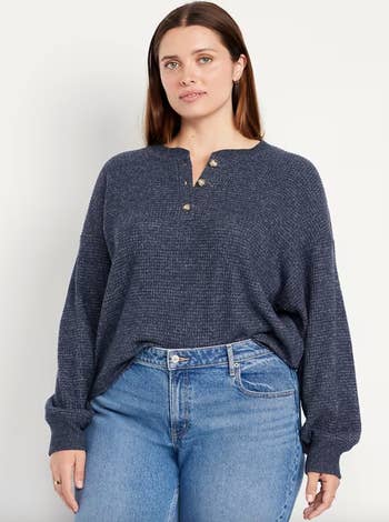 Person wearing a casual textured long-sleeve apical  with fastener  details and jeans, suitable for a buying  feature