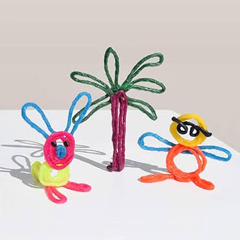 A rabbit, palm tree, and person made out of sculpting sticks