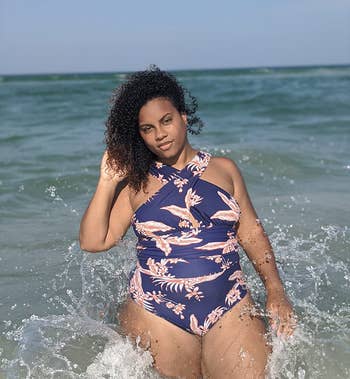 reviewer wearing navy blue bathing suit with red tropical print on it