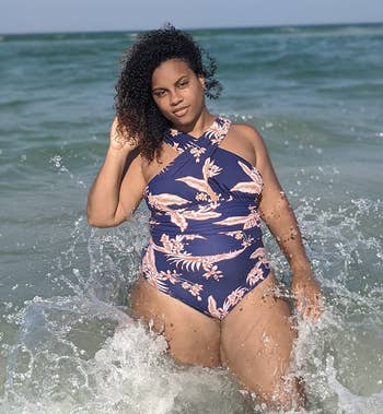 reviewer wearing navy blue bathing suit with red tropical print on it