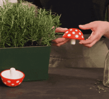 gif of someone flipping the mushroom funnel inside out and using it to pour oil into a bottle