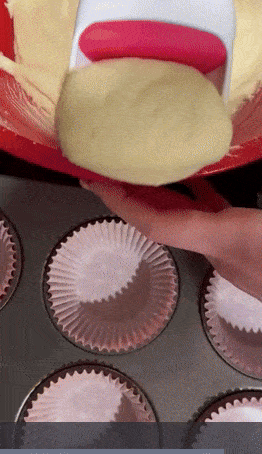 reviewer scooping batter into cupcake liners for baking