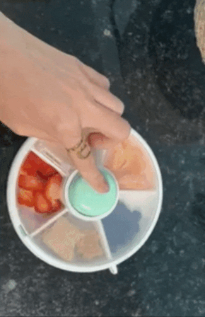 gif of reviewer pushing the center button of the snack container, showing how the lid moves to always have one space open