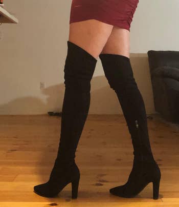 a reviewer wearing the over-the-knee boots in black 