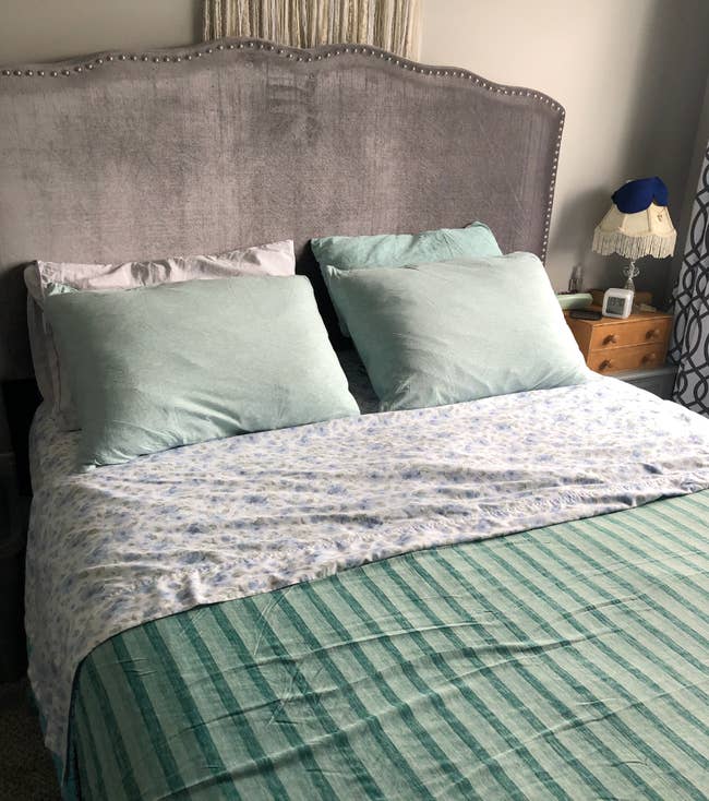 A neatly made bed with a patterned comforter and two pillows in a bedroom setting, demonstrating home bedding options