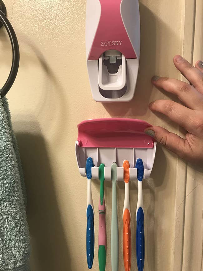 reviewer image of the wall mounted toothbrush holder and toothpaste dispenser on their bathroom wall