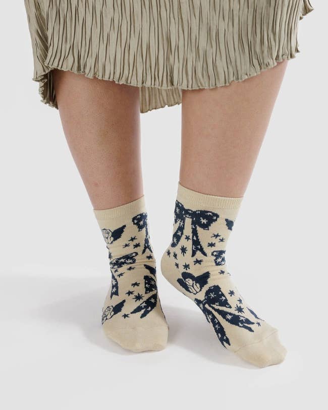 cream-colored socks with navy blue cherub and bow details