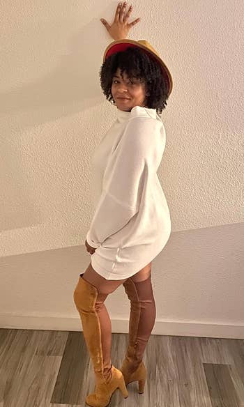 reviewer showing side view of the white tunic worn with knee high boots