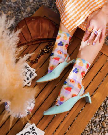 model in slingbacks with gingham socks printed with different colorful fruits