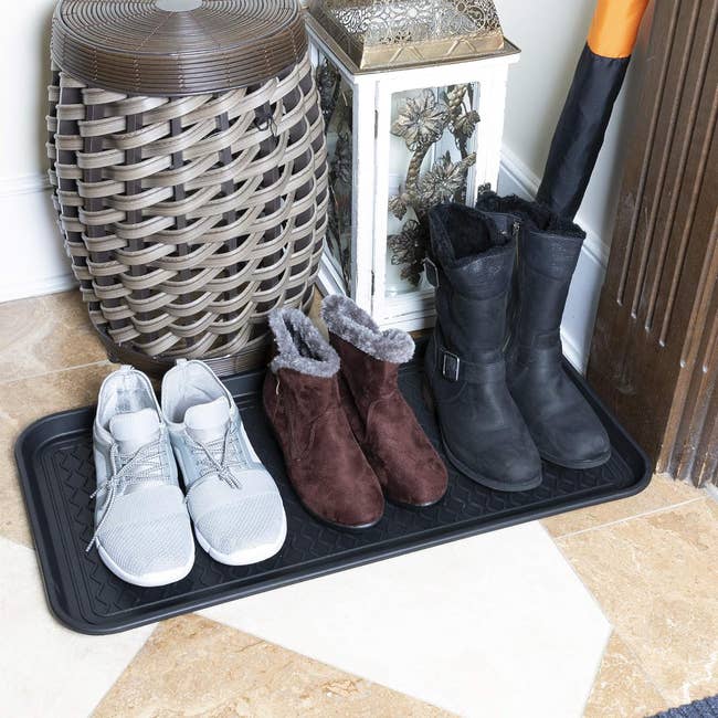 the boots tray with three pairs of shoes on it