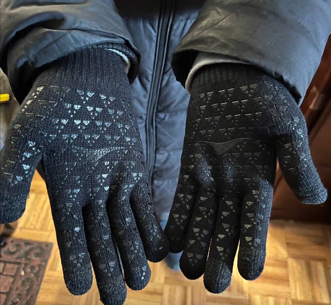 black touchscreen gloves with indententations on them on a reviewers hands 