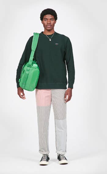 model carrying green go-bag over shoulder