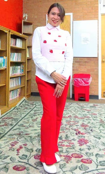 a reviewer standing in their classroom wearing the strawberry vest