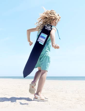 Child successful  a sleeveless romper runs connected  a formation  carrying a large, rectangular container  labeled 