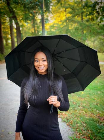 reviewer utilizing umbrella outside