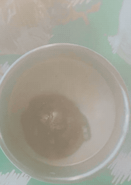 a gif of the hot chocolate bomb melting in a mug of milk and marshmallows coming out