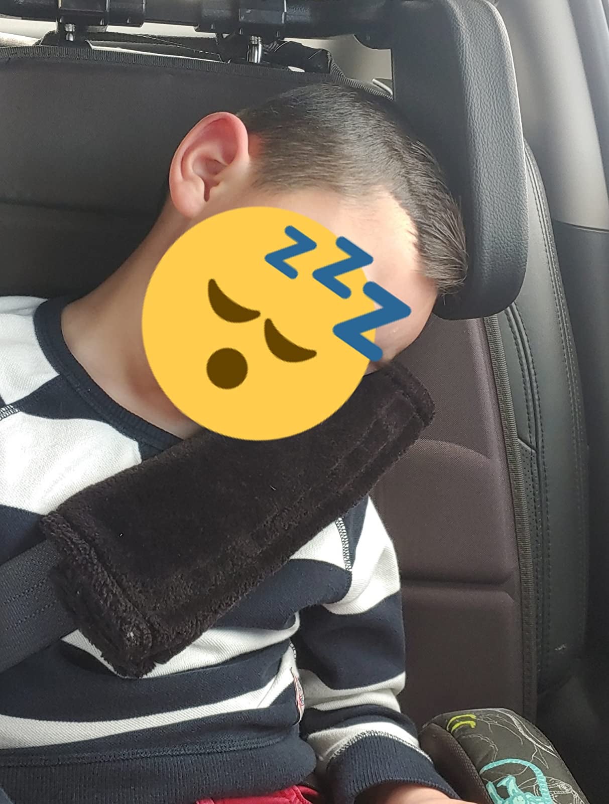 reviewer showing their child using the headrest pillow in a car