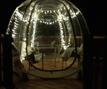 the pop up tent lit up with string lights at night