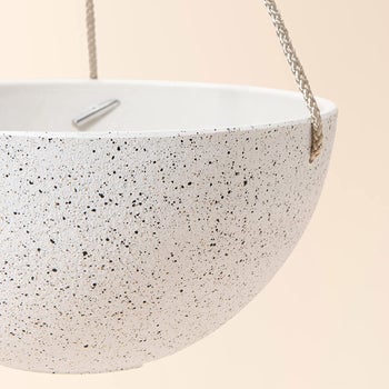 white speckled planters hanging from roof