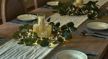 the same lighted faux eucalyptus garland but wrapped around candles on a table