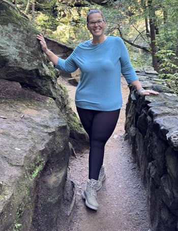 Person successful casual outdoor attire walking connected a wood trail, surrounded by greenery and rocks