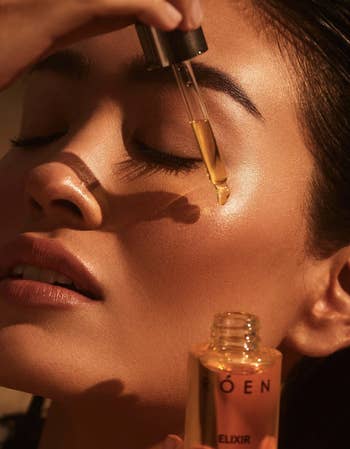 model putting on the roen facial oil