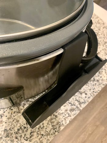 Close up showing that the hook is connected to the side of the slow cooker 